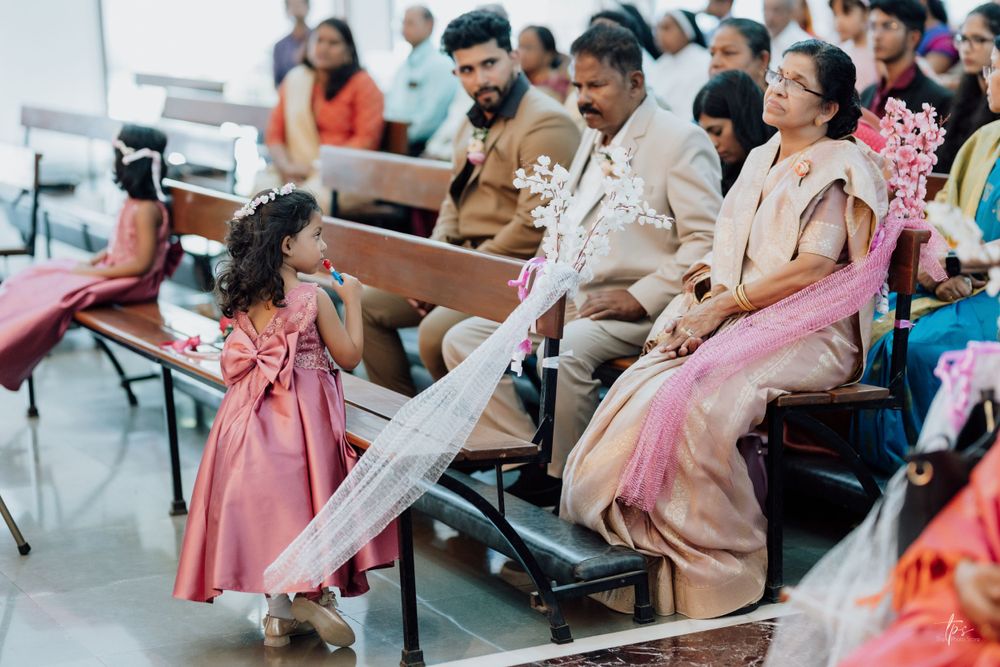 Church congregation gathered for wedding ceremony with pink and white decor.