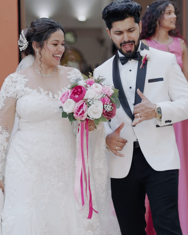 Wedding couple shares joyful moments in formal white attire with pink floral bouquet.