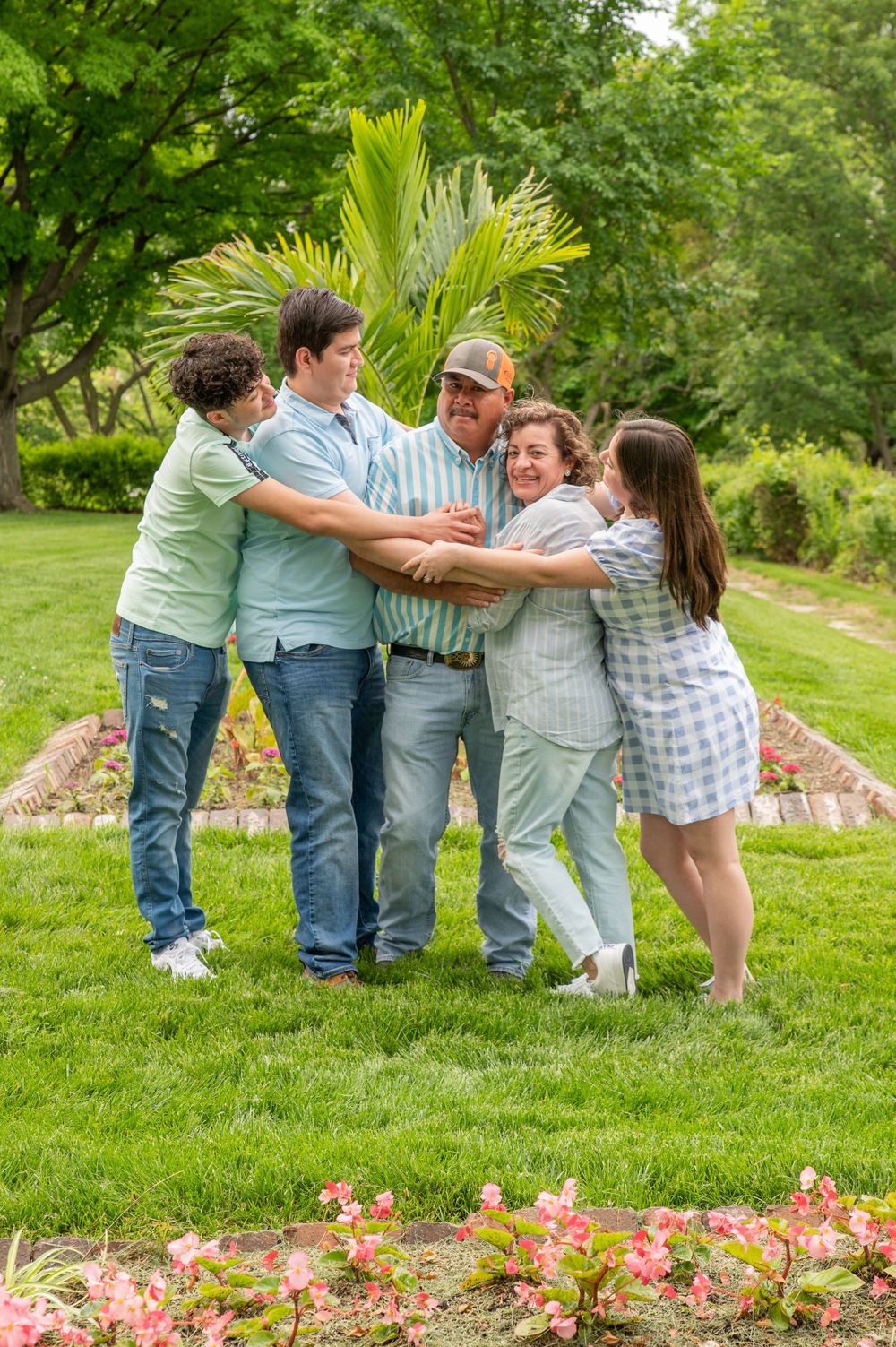 Summer family photo session in Omaha, Nebraska. Family is all hugging each other and smiling.