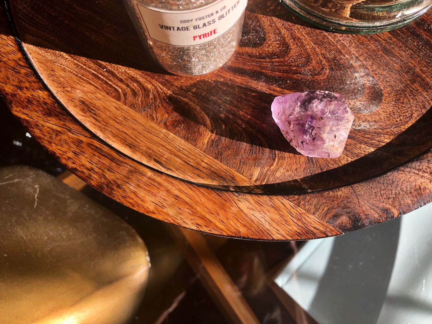 Rustic wooden serving boards arranged on a dark surface with pink crystal decor.
