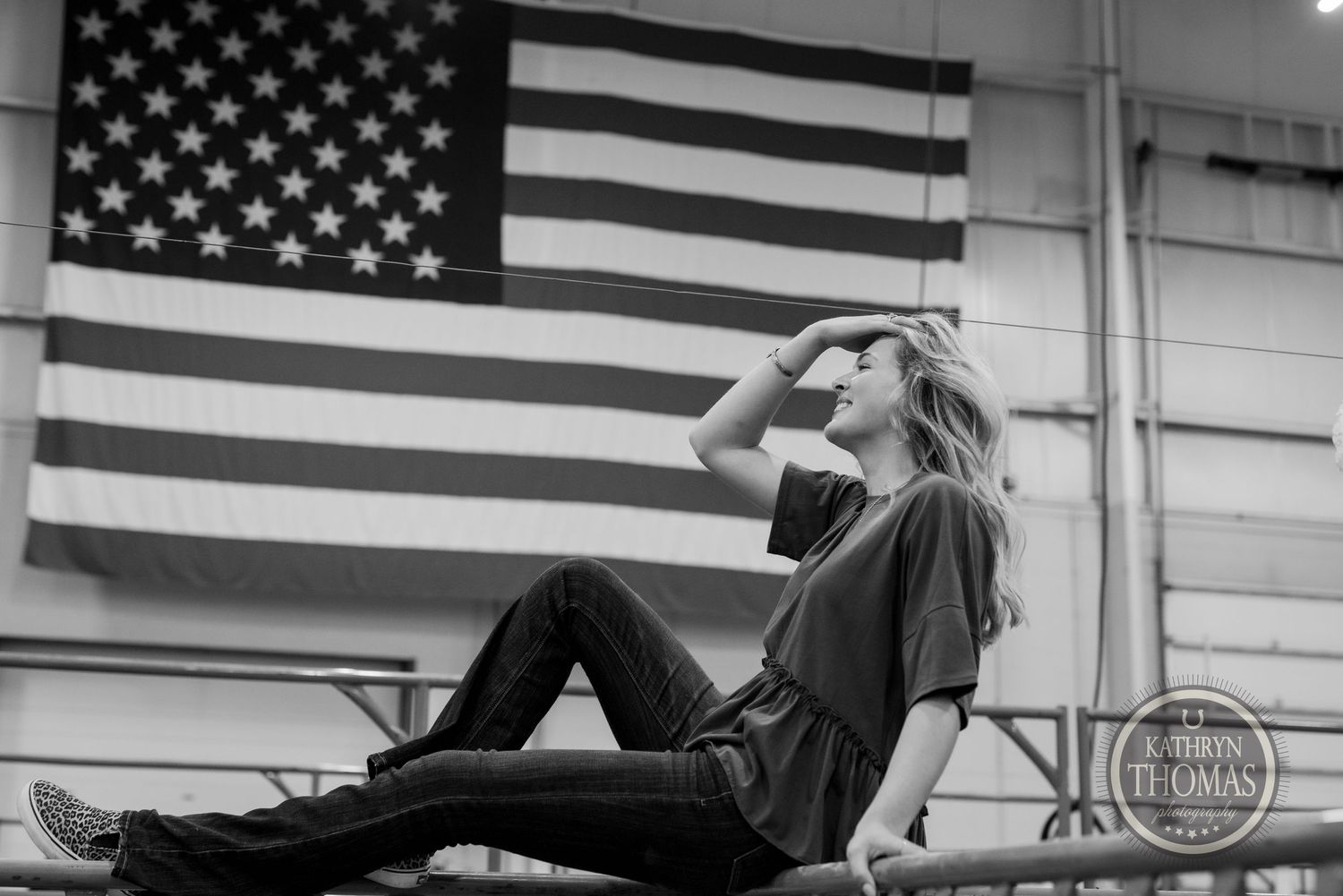 Black and white portrait with American flag background showing contemplative pose.