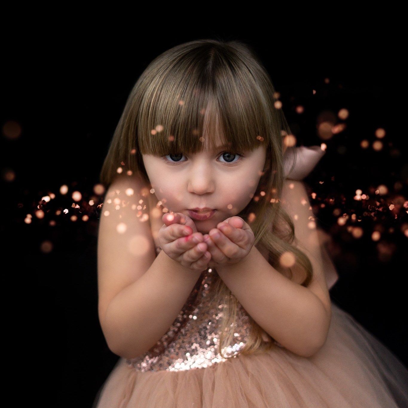 Dreamy portrait against dark background with sparkling bokeh lights.