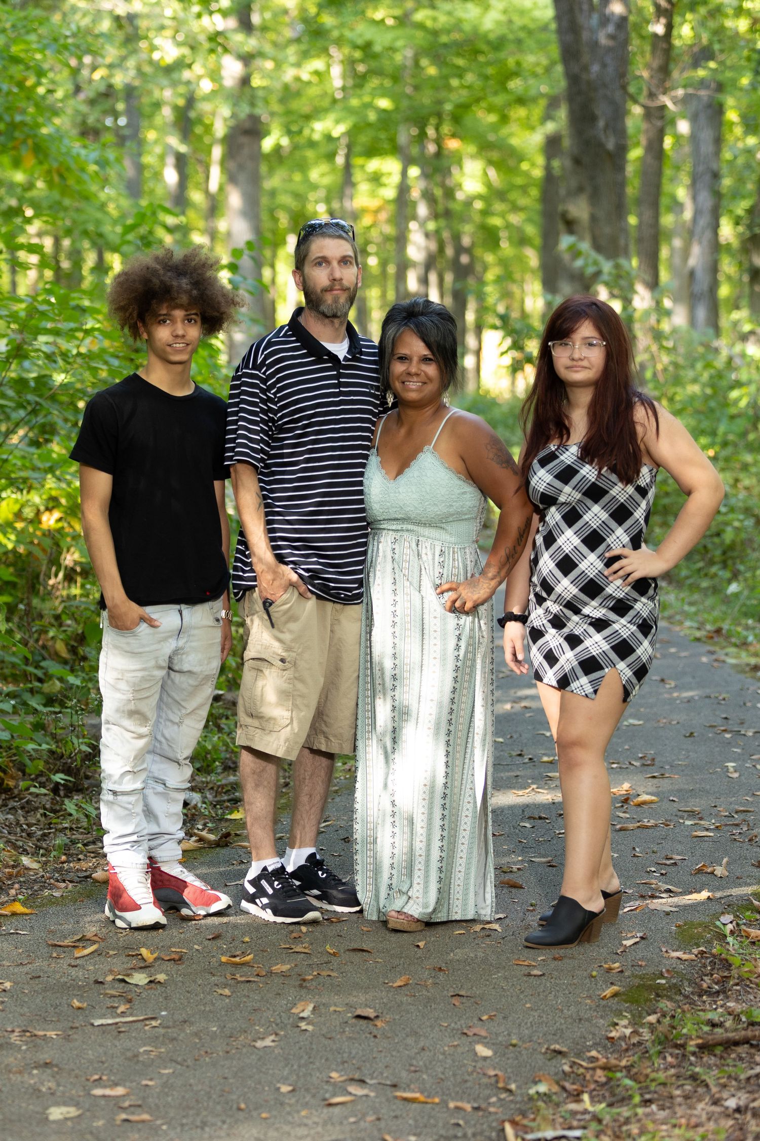 A family of four pose nicely for their family pictures in the Illinois forest.