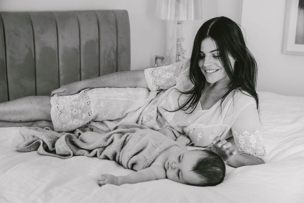 Black and white image of peaceful mother and baby resting in bed.