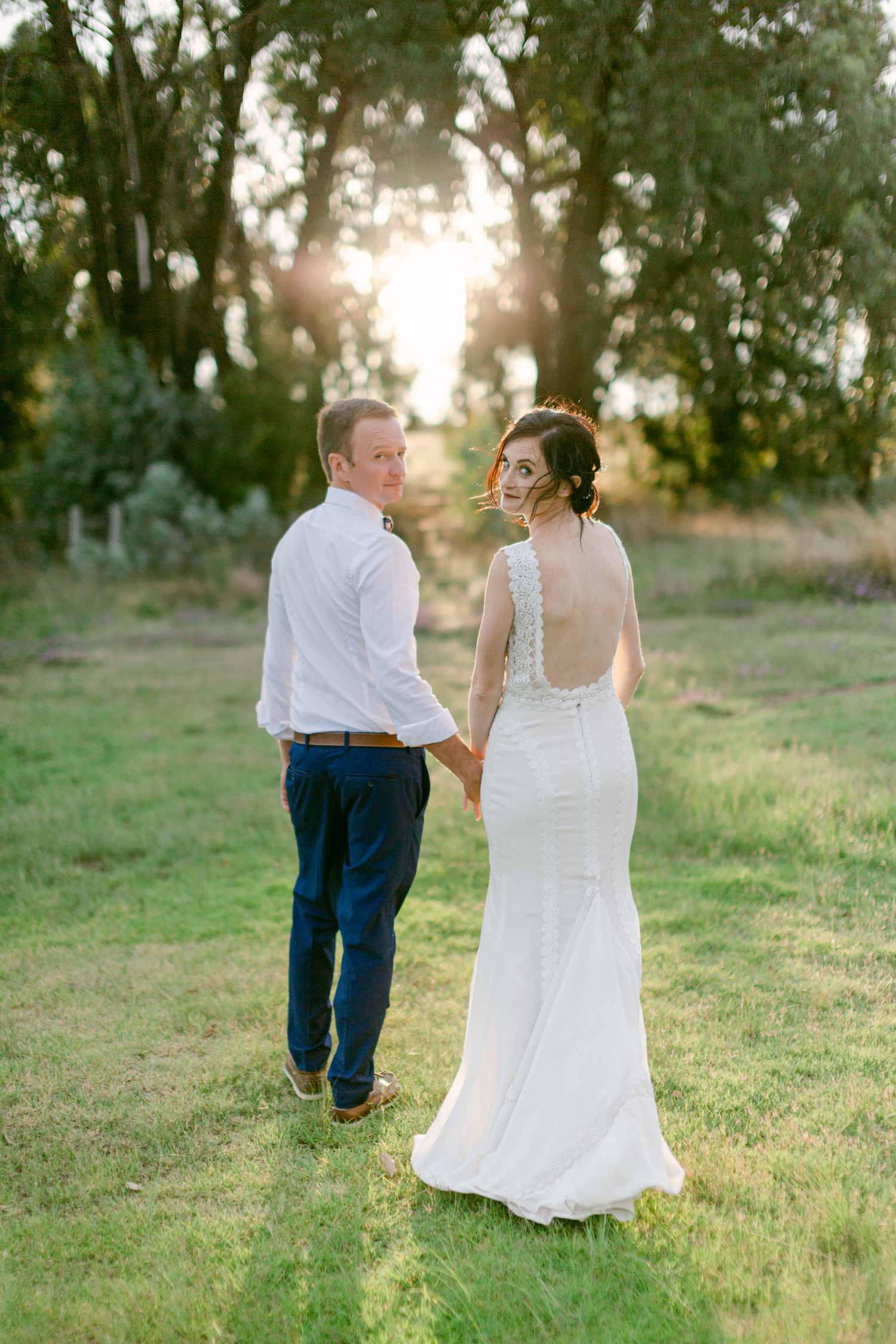 Bride and groom walking in a field
