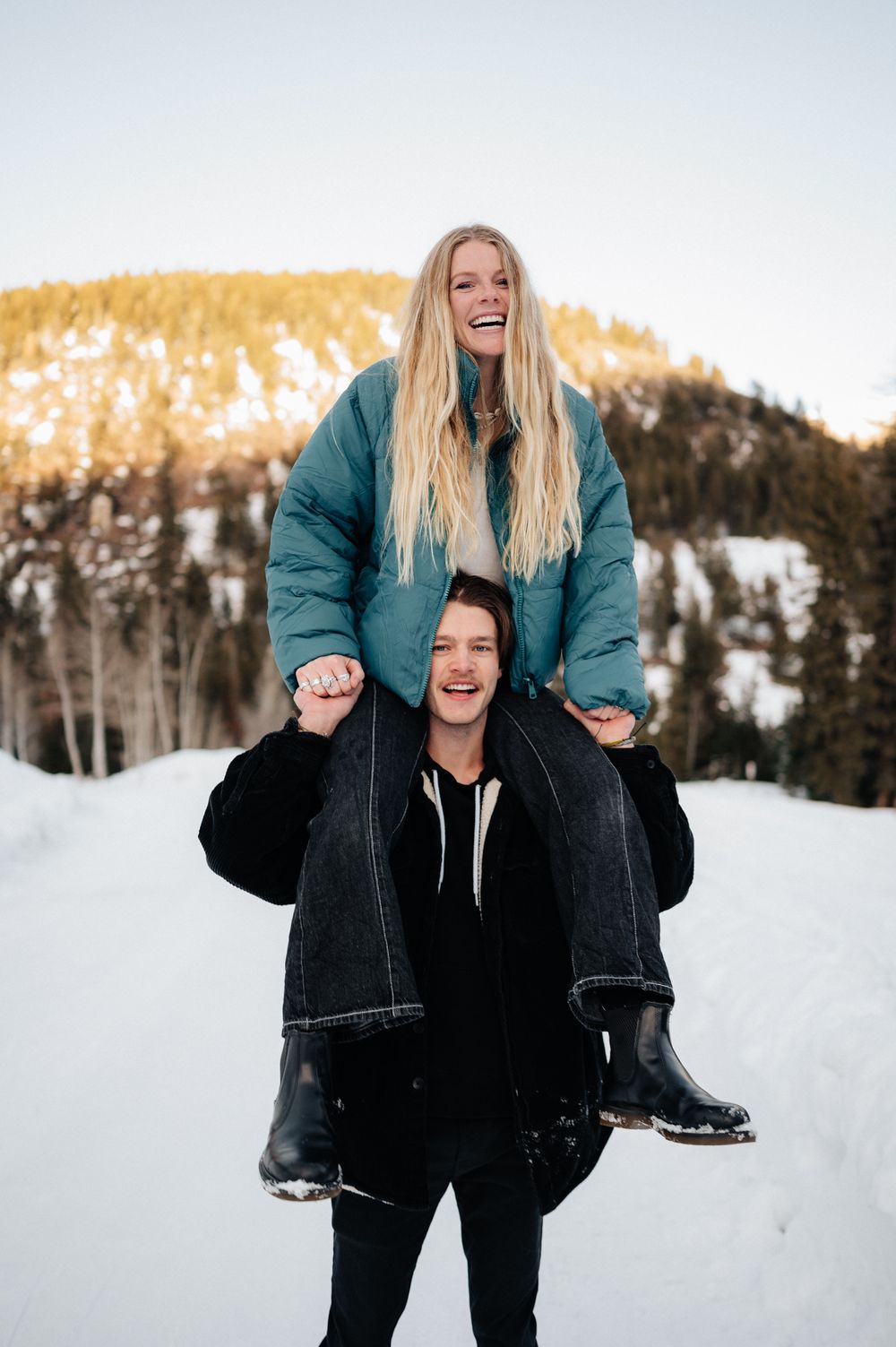 A playful winter scene with people enjoying a piggyback ride in the snowy mountains.
