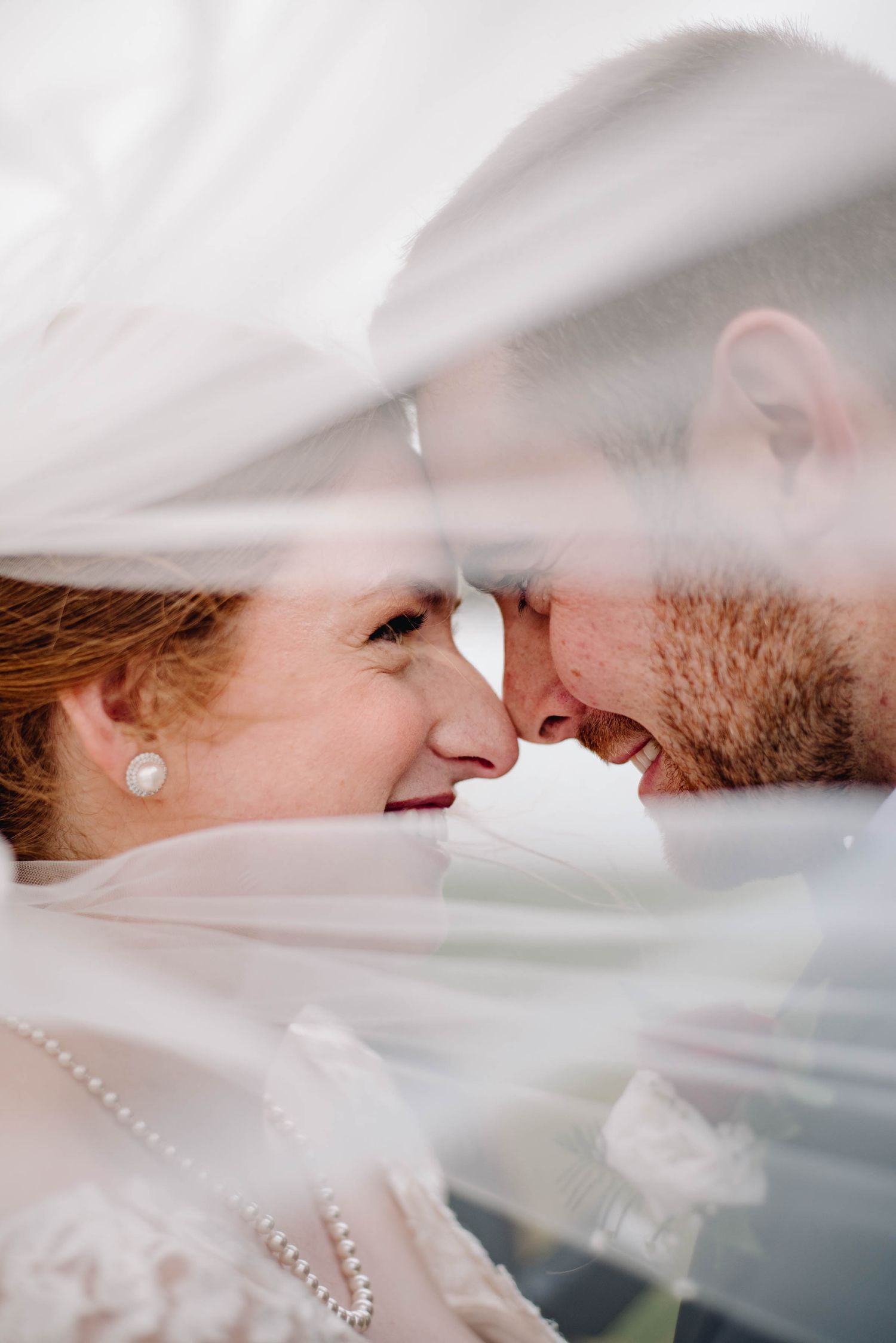 Close up photograph of bride and groom smiling at one another in Mount Uniacke, Nova Scotia.