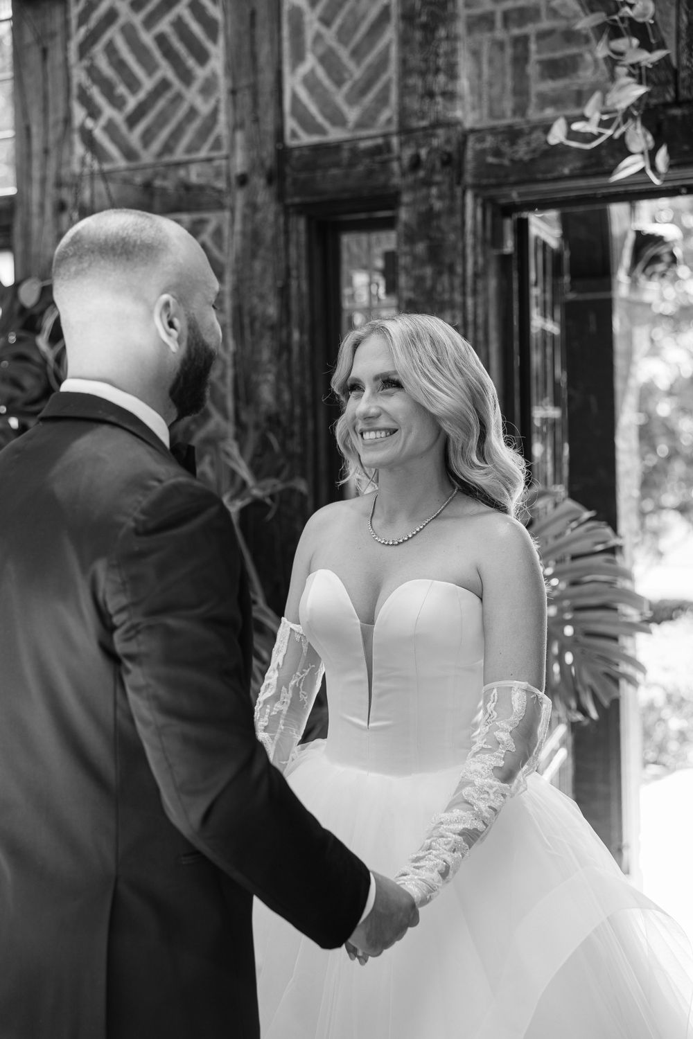 Black and white candid moment between couple during wedding ceremony.