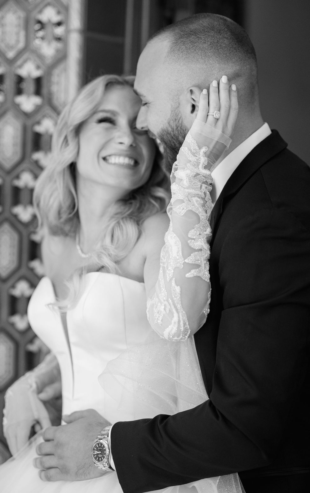 An intimate black and white wedding moment captured against decorative tilework.