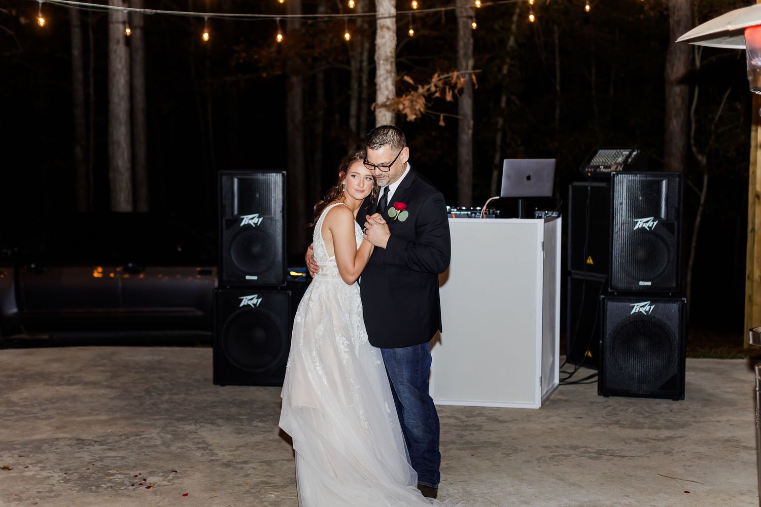 Couple sharing their first dance at a dimly lit wedding reception.