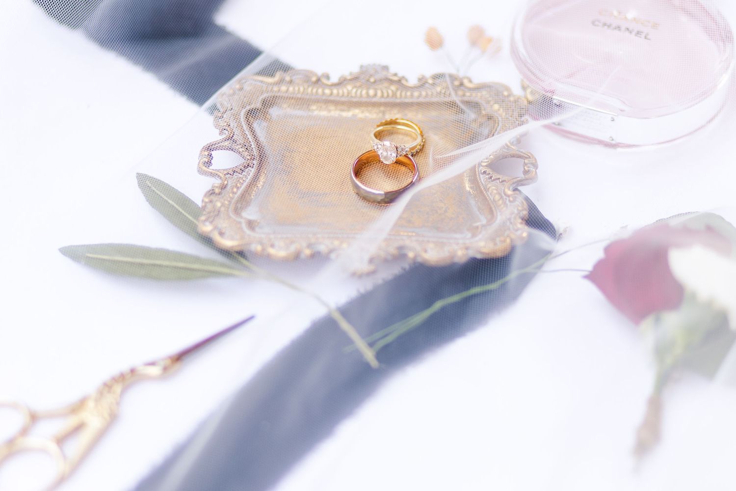 Wedding rings displayed on an ornate vintage tray with soft focus.