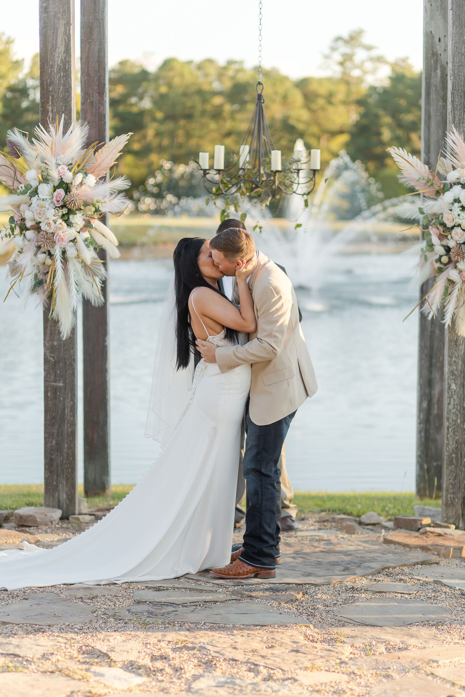 Romantic waterfront wedding photos with decorative floral arrangements and wooden pillars.