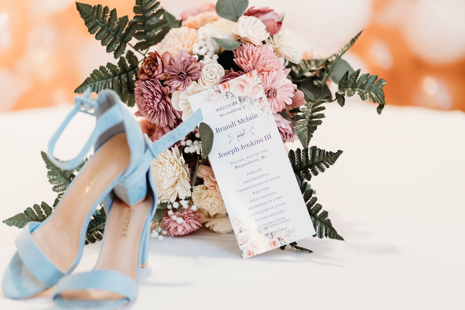 Wedding details featuring floral arrangements and invitation cards in pink and blue tones.