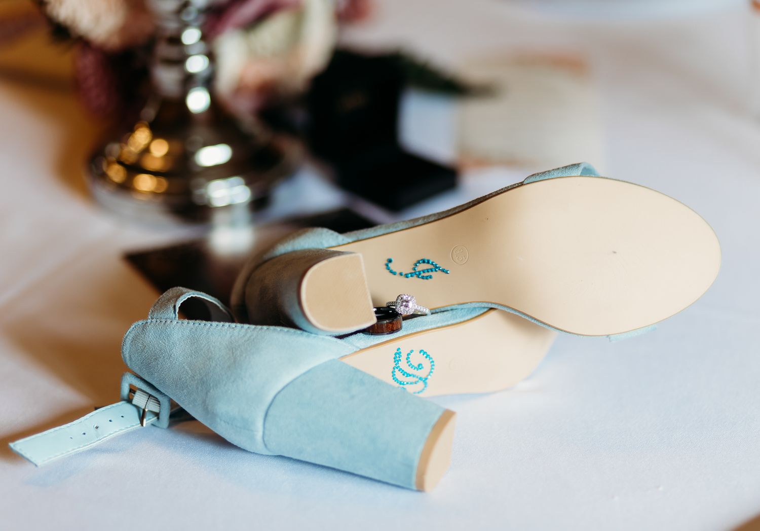 Light blue wedding shoes arranged on white surface.