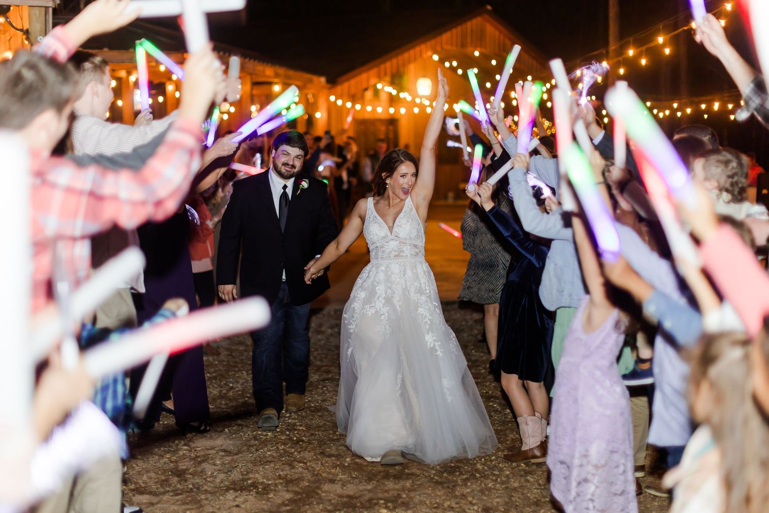 Nighttime wedding celebration with string lights and dancing guests.