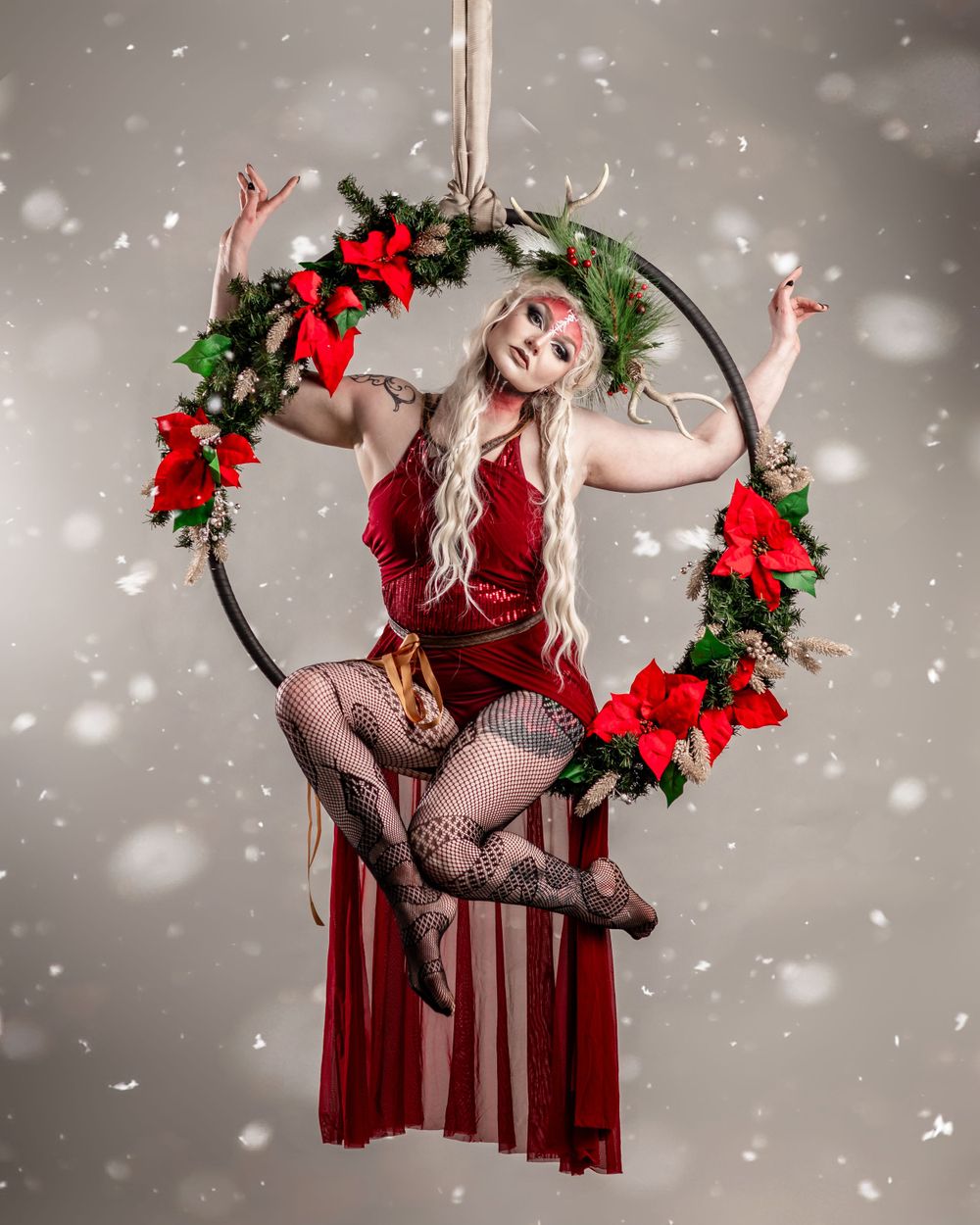 Aerialist in winter-themed studio on light grey background; aerial arts photography, aerial portraits, and aerialist photoshoot.