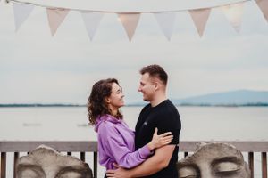 A romantic moment captured under white bunting flags at an outdoor celebration.