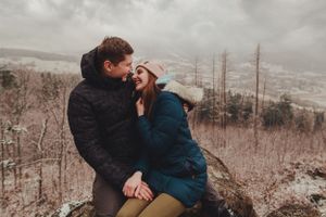 A romantic embrace captured against a misty mountain backdrop.