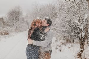 A couple embraces in falling snow creating a magical winter moment.