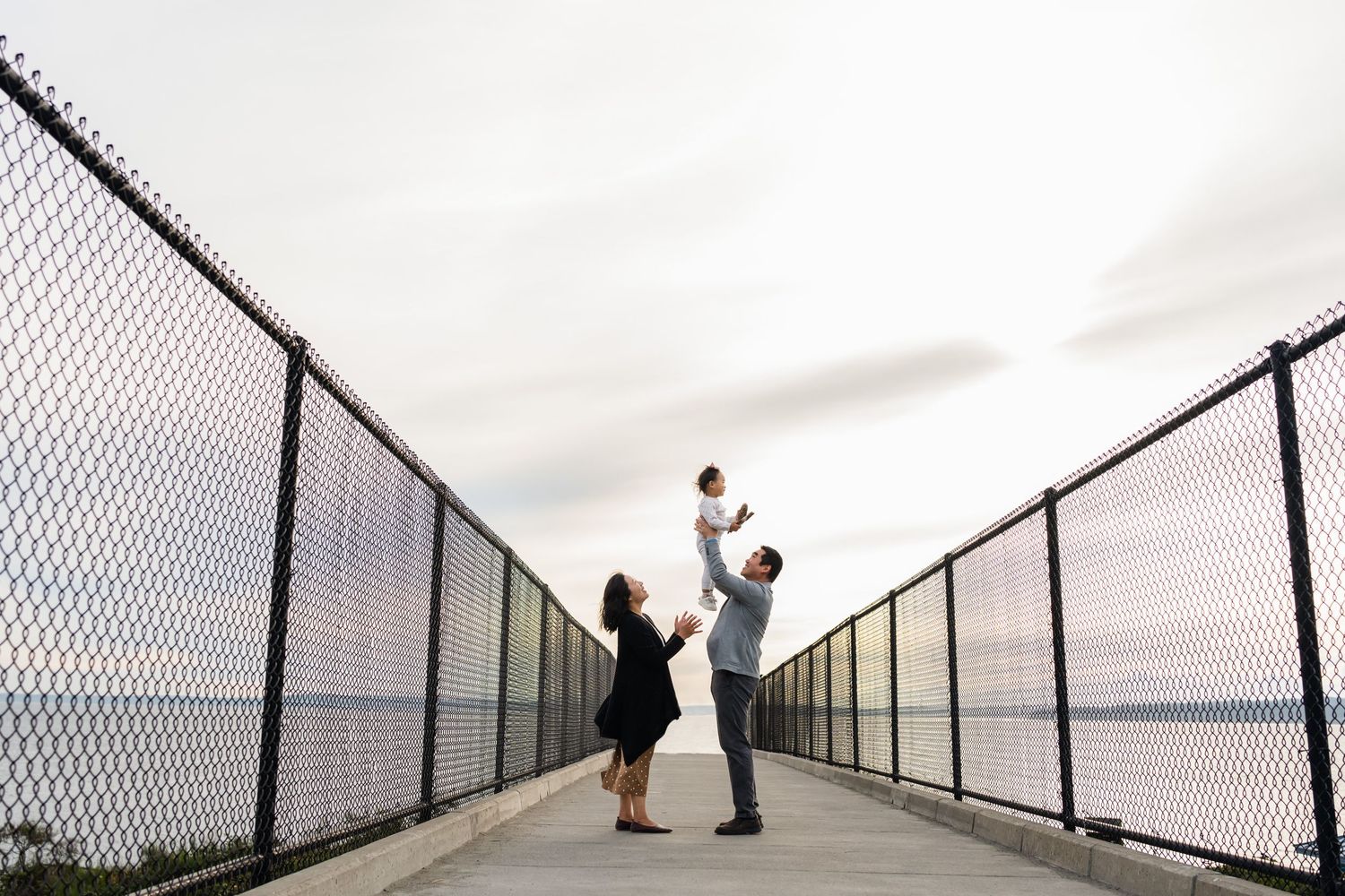 Parents throw daughter into the air on the bridge in Shoreline.