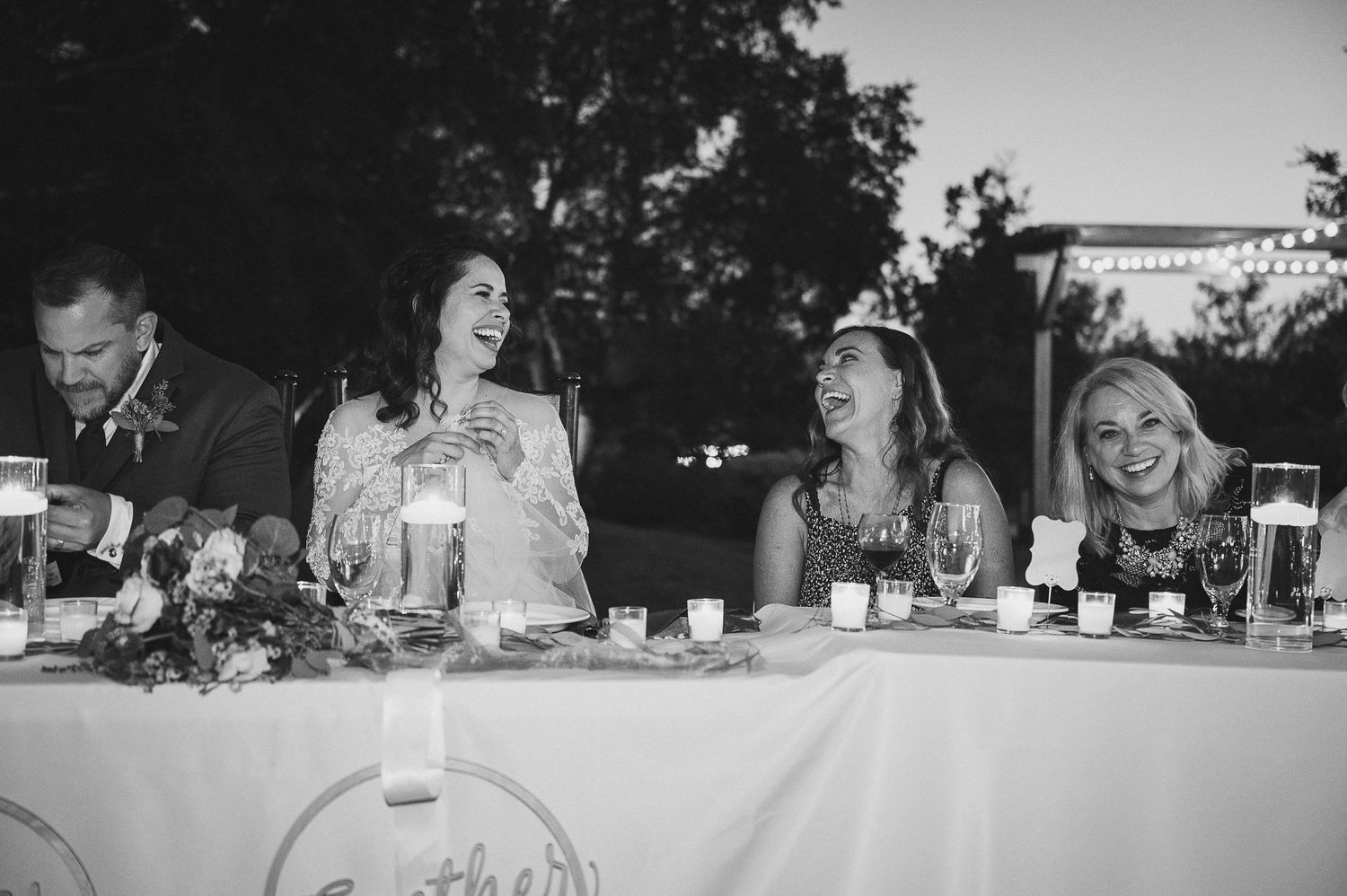 Guests enjoying conversation at an outdoor reception dinner table.