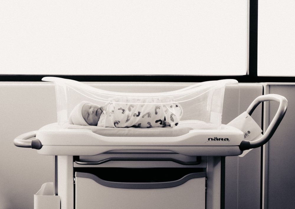 a baby boy sleeping in a bassinet at Salina Regional Health Center during a fresh 48 in-hospital session.