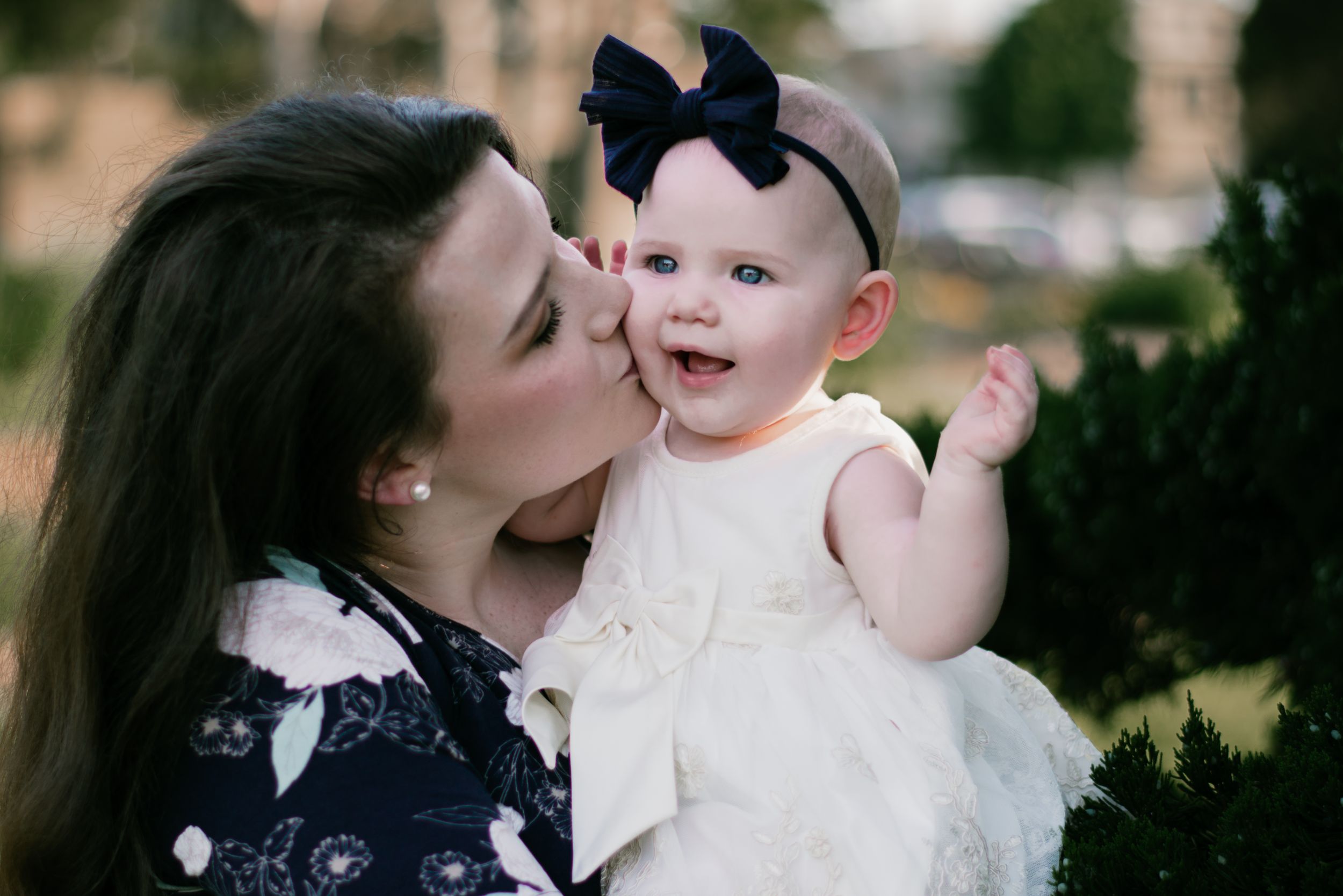 A young mom gives her baby kisses
