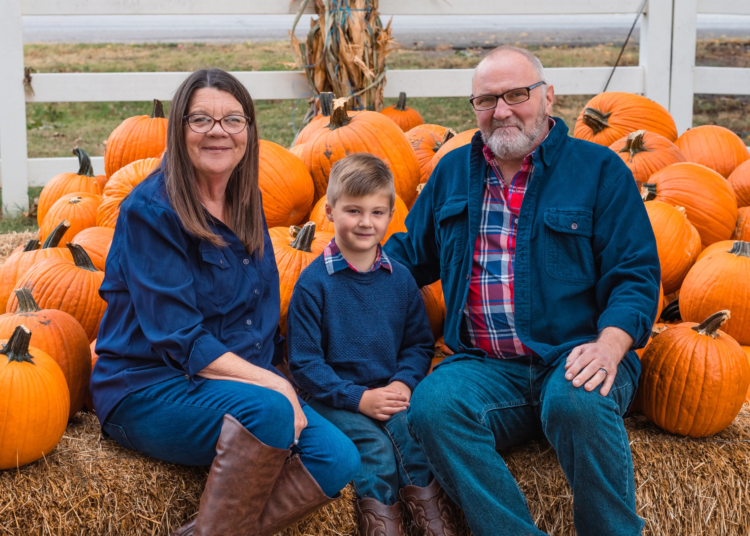 Two grandparents posing with their adorable grandson