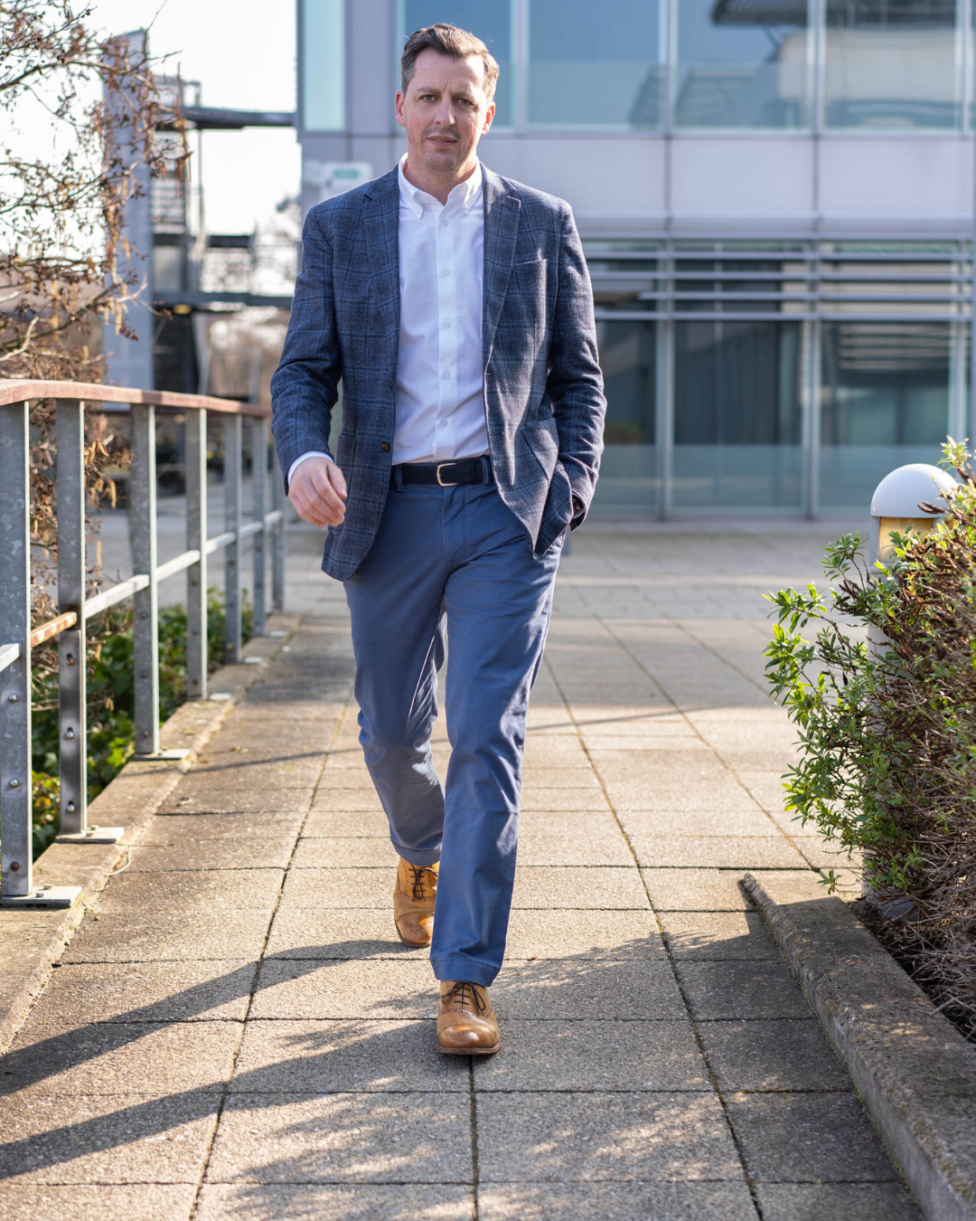 Image of a Whitely based recruitment business CEO walking towards the camera. He's wearing a blue jacket and trousers