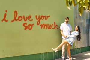 couple poses in front of mural