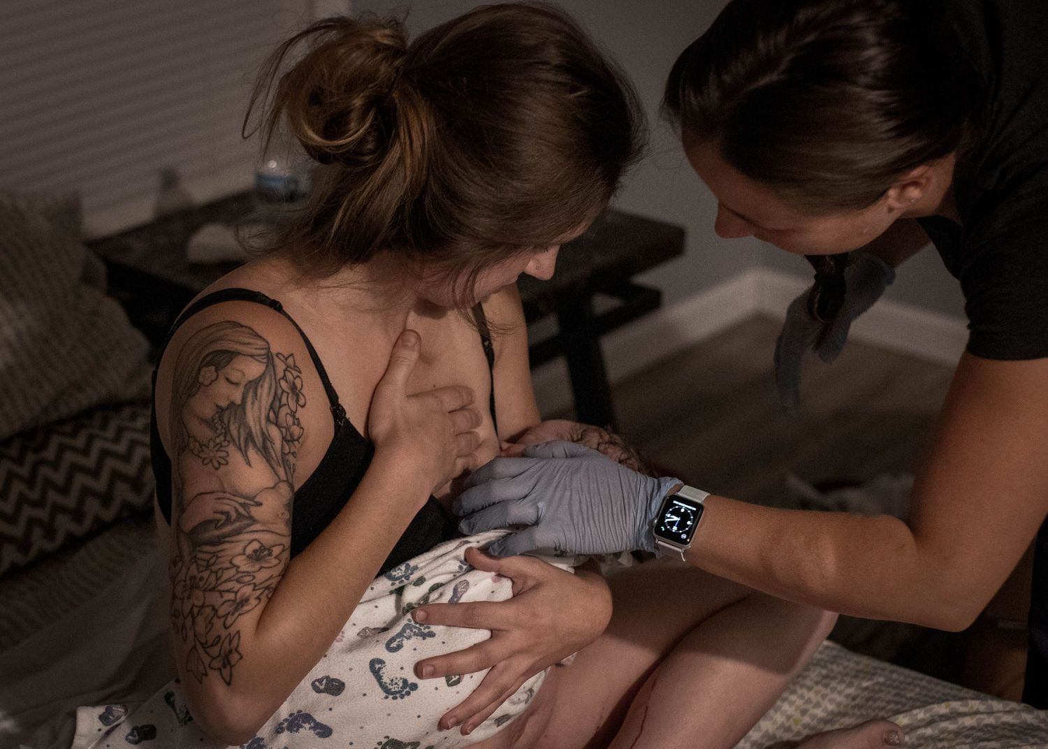 Midwife providing breastfeeding support to a new mom just after birth in Sioux City, IA.