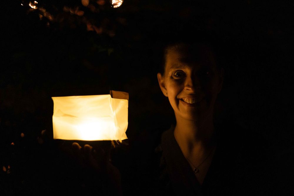 A luminous paper lantern glows against a dark background creating mysterious ambiance.