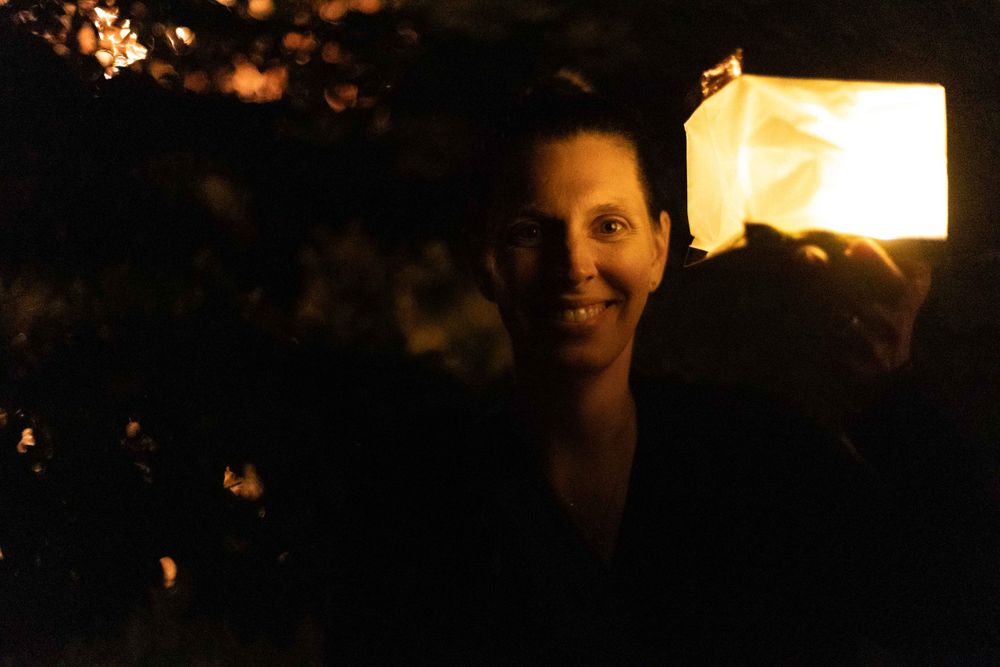 A nighttime portrait illuminated by soft lantern light creating a warm glow.