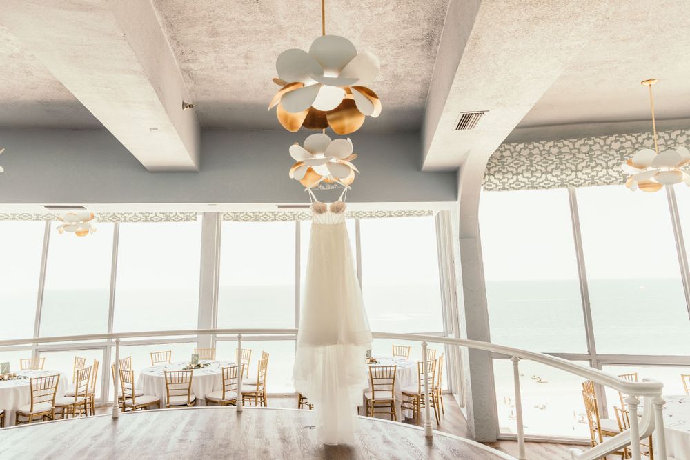 Modern wedding venue interior with white ceilings and large windows overlooking the water.
