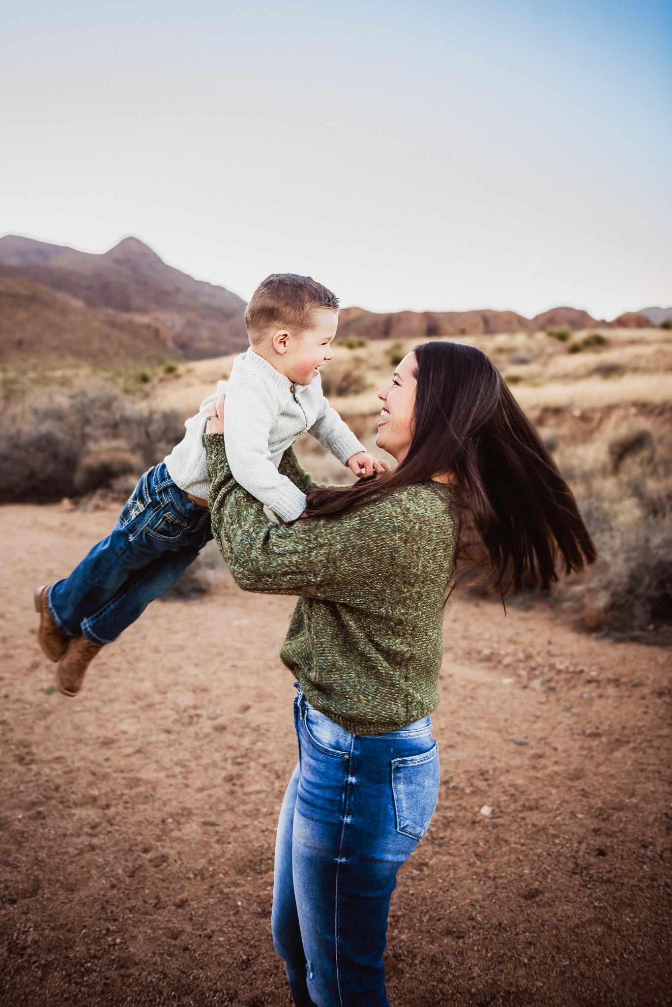 A joyful outdoor moment captured against a desert mountain backdrop in warm light.
