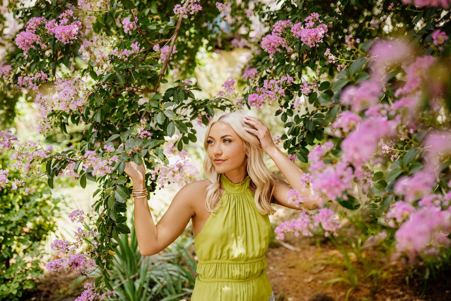 Ethereal garden portrait among blooming pink flowers and greenery.