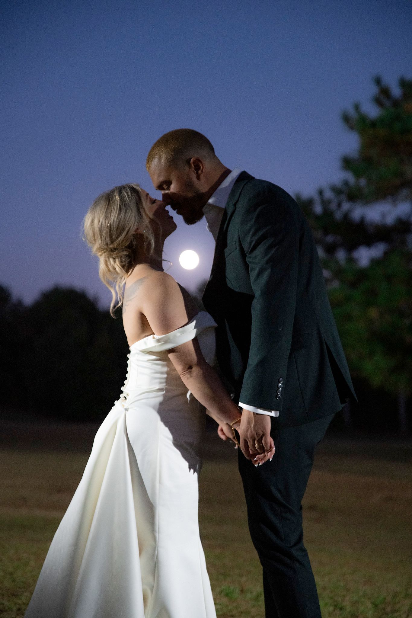Bride and groom nighttime wedding portraits with shinning moon in background