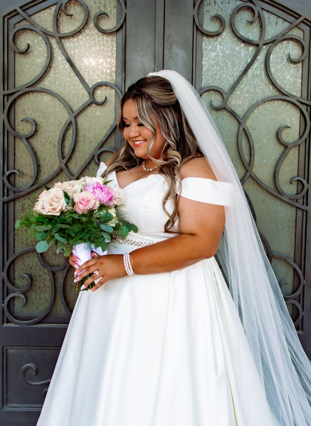 Artistic bridal portraits featuring white gown and bouquet against decorative iron door.