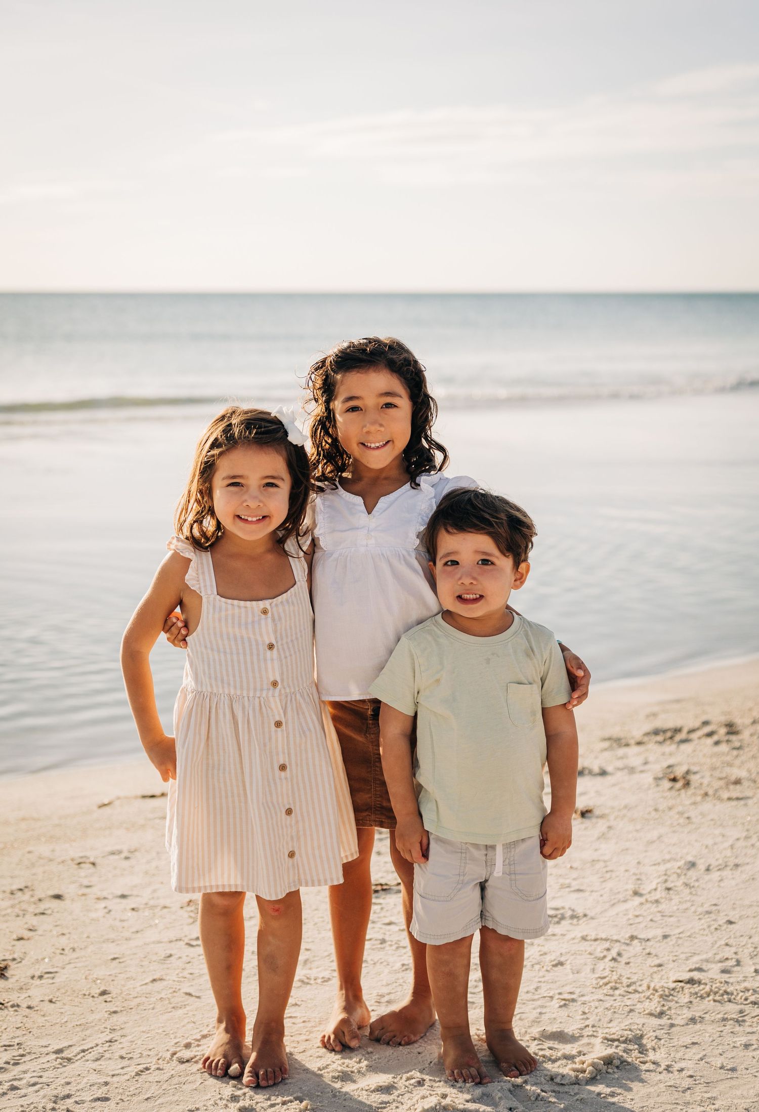 Kids smiling at the camera on Siesta Key beach photograph taken by Sarasota family photographer Samantha Brown Artistry.