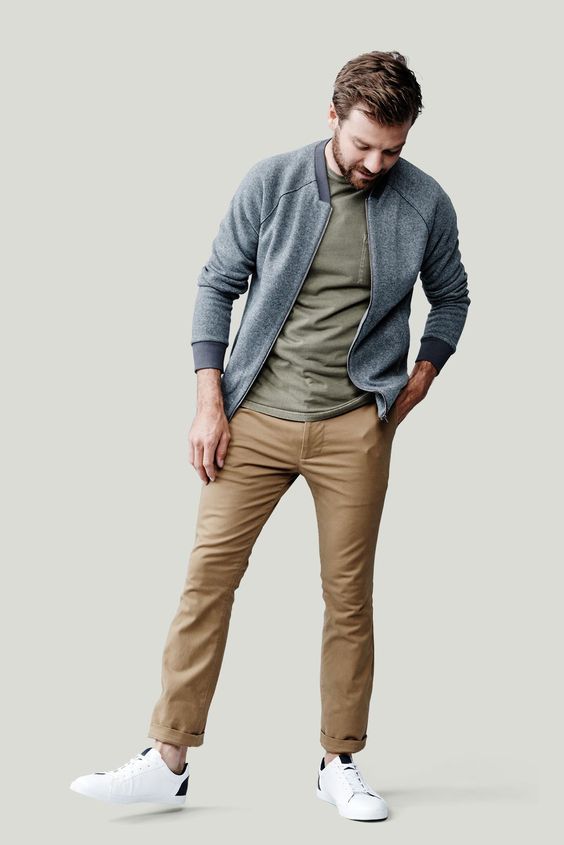 Modern casual men's outfit with gray zip jacket, olive shirt and khaki pants.