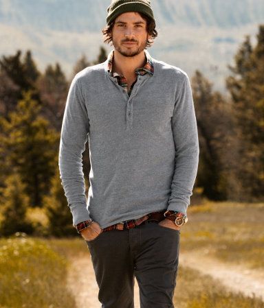Casual outdoor portrait of man in gray pullover sweater and beanie hat in mountain setting.
