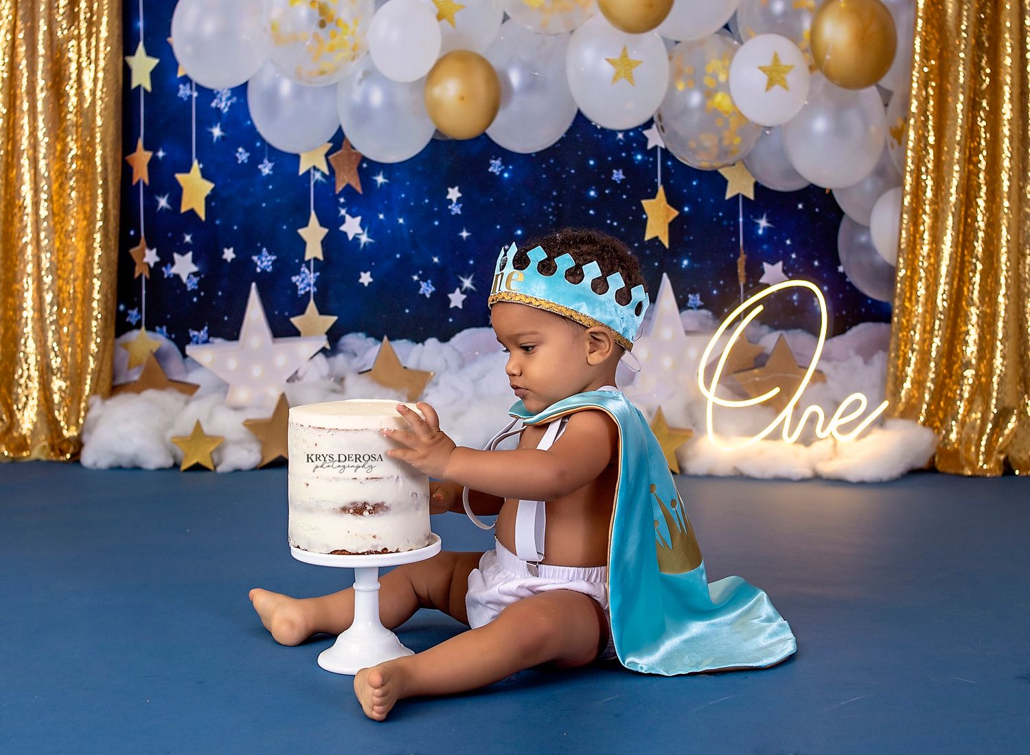 Birthday setup with gold curtain, balloon arch, and starry night theme.