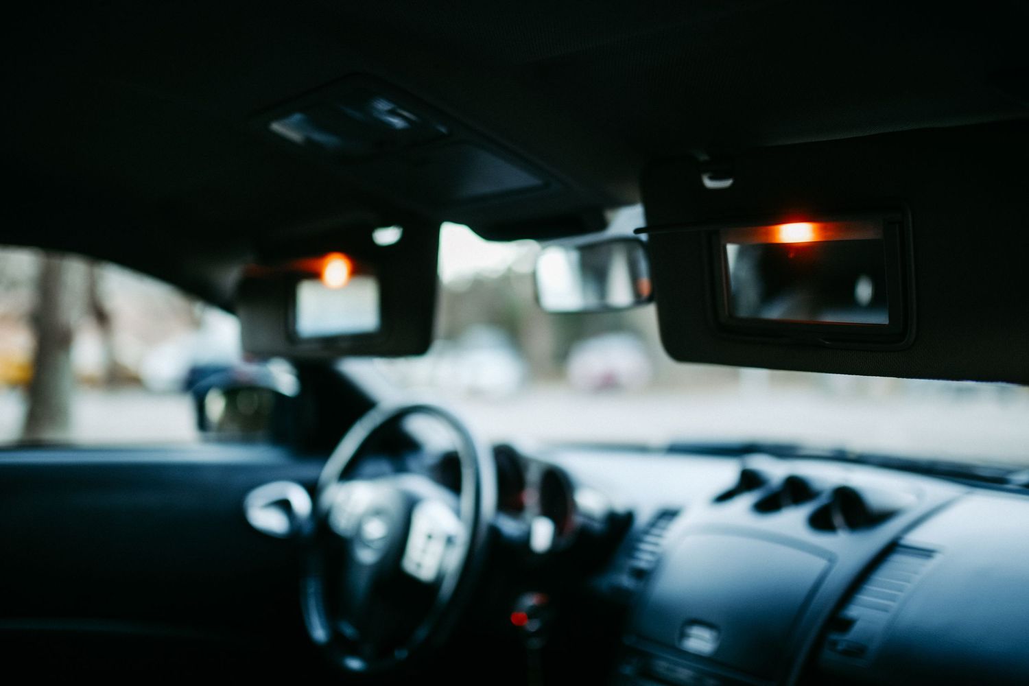 Blurred interior view of car dashboard through windshield.