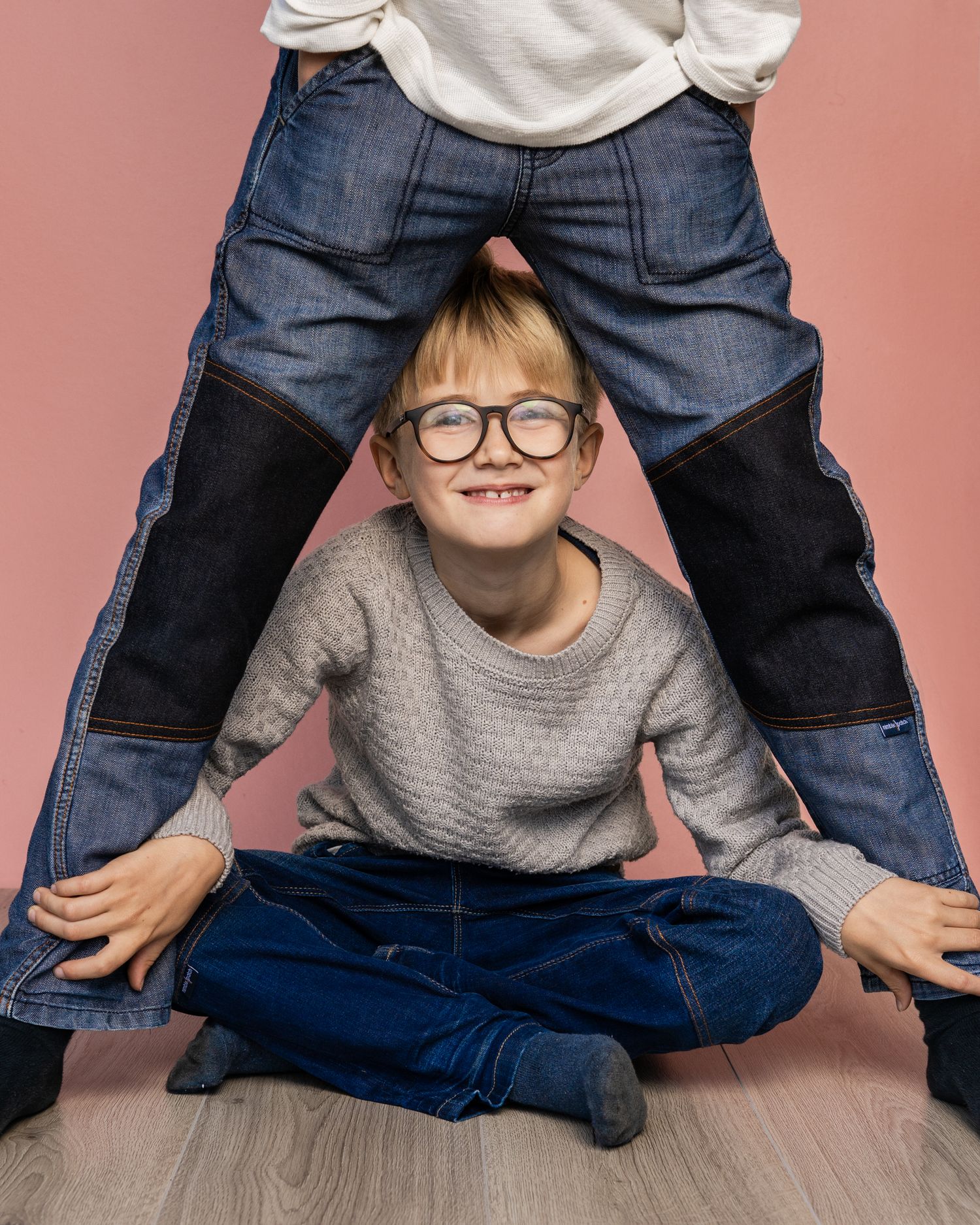 Två pojkar klädda i mörkblå jeans poserar vid företagsfotografering