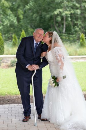 Wedding portrait on brick pathway surrounded by landscaped garden.