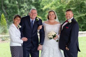 Wedding party portrait outdoors with green landscape background.