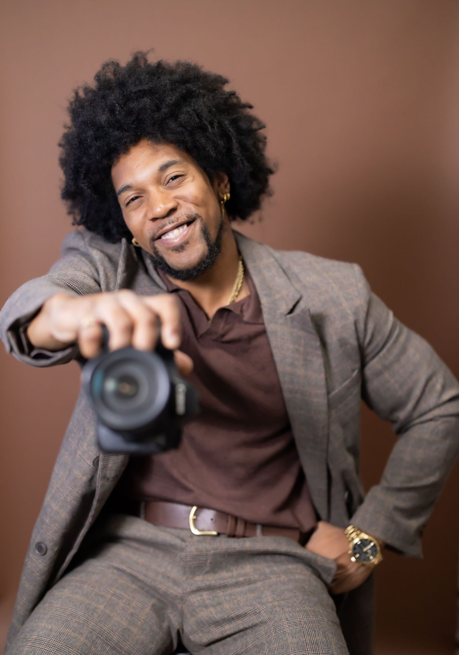Confidently presenting myself as a professional photographer, I hold my camera with expertise, ready to capture moments.