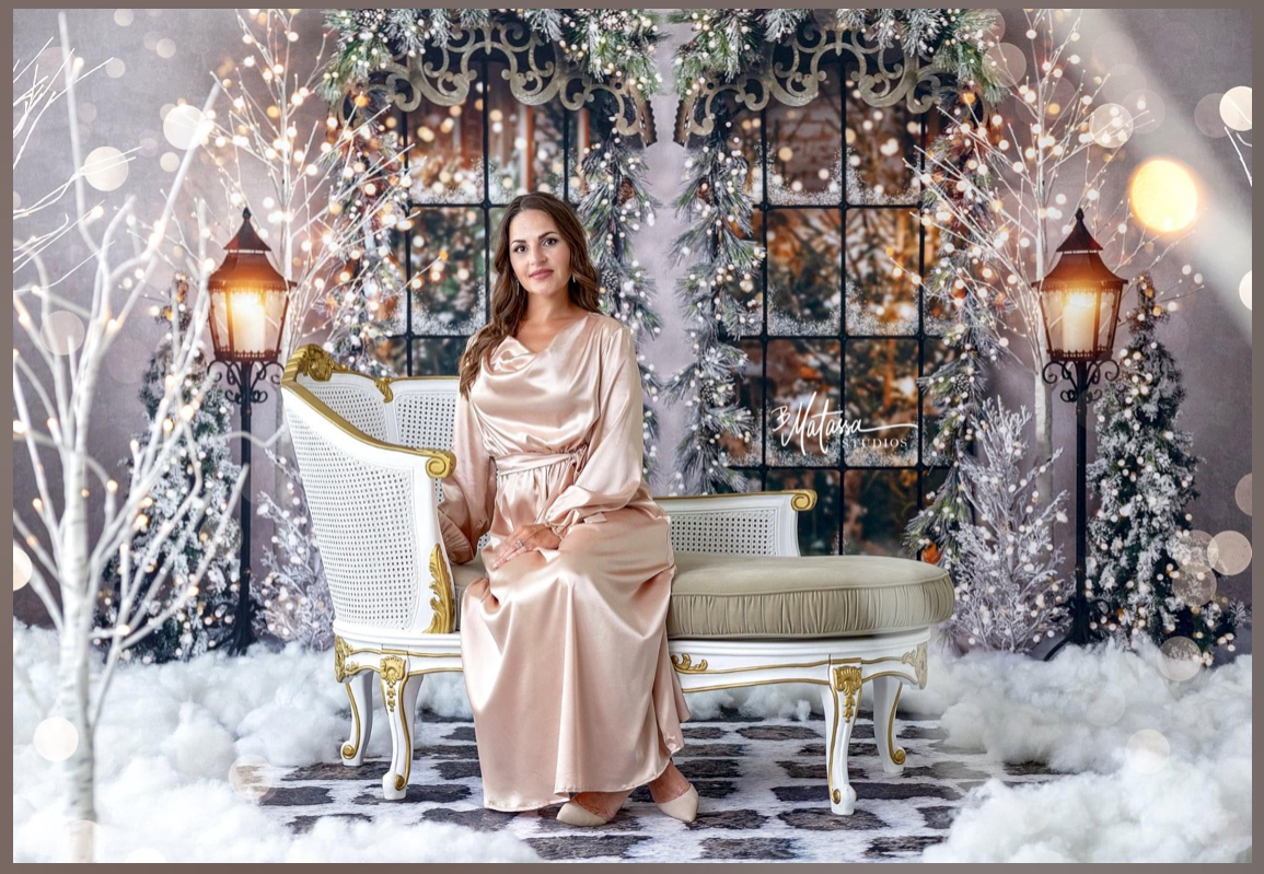 Luxurious winter wonderland photo set with lanterns, snow-covered trees and elegant seating.