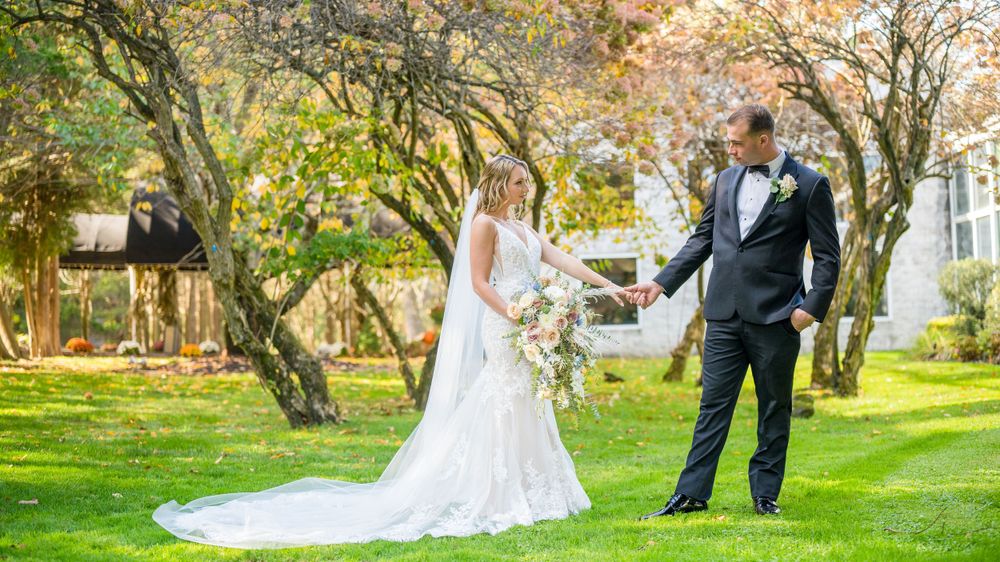 Newlyweds holding hands, enjoying their photo session at Flowerfield Celebrations