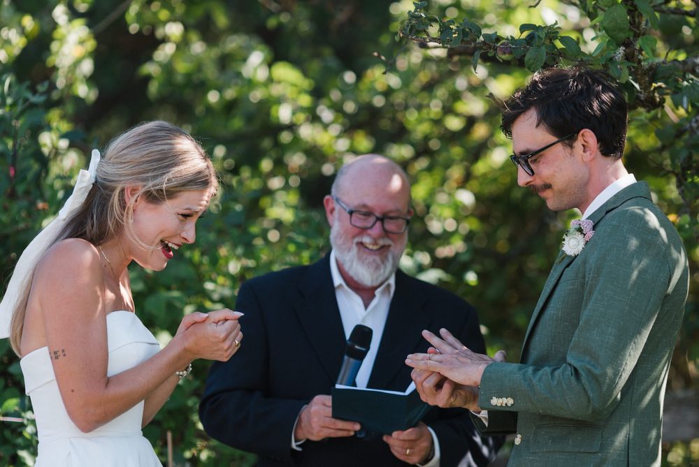 Emery laughs as Matt tries to put the wedding ring on his finger